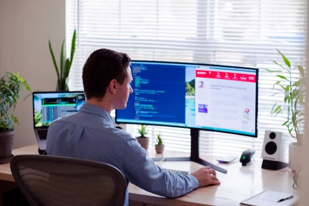 man-in-gray-dress-shirt-sitting-on-chair-in-front-of-computer-monitor-b6jinerwmz0